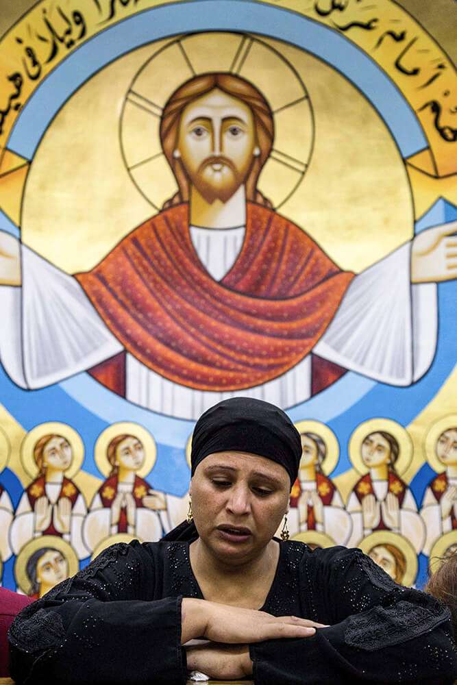 Familiar de los cristianos coptos egipcios que fueron decapitados por yihadistas en la playa de la ciudad libia de Sirte en Libia en 2015, en la Iglesia de los Mártires el 15 de mayo de 2018