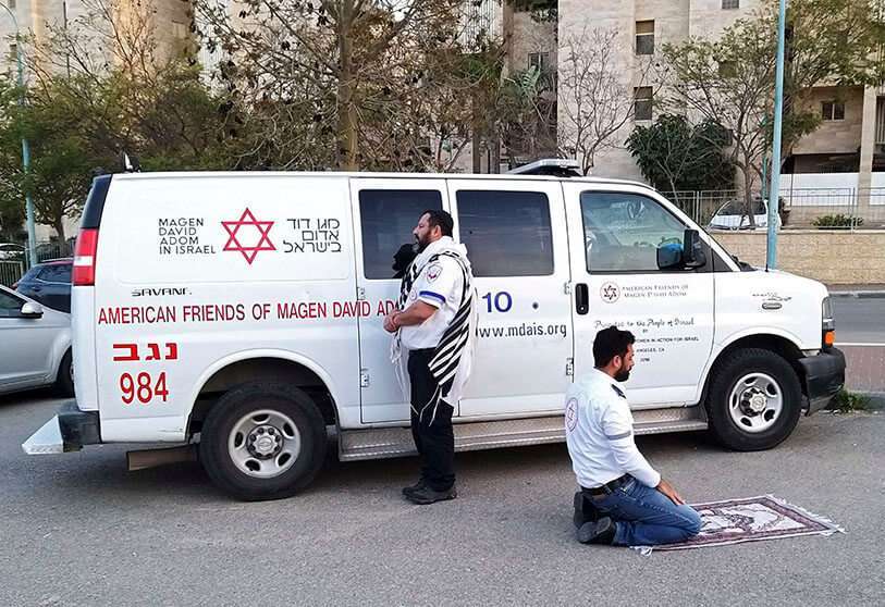 Dos paramédicos rezando al paso de la ambulancia: un judío de Beersheba frente a Jerusalén, y un árabe de Rahat frente a la Meca