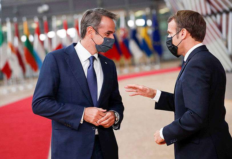 El presidente de Francia, Emmanuel Macron (Derecha), habla con el primer ministro de Grecia, Kyriakos Mitsotakis, durante su llegada a la cumbre de la Unión Europea (UE) en el edificio del Consejo Europeo en Bruselas el 1 de octubre de 2020