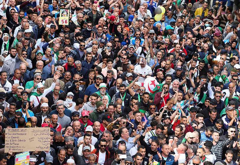 Manifestantes llevan banderas y pancartas nacionales durante una protesta antigubernamental en Argel, Argelia, el 13 de marzo de 2020