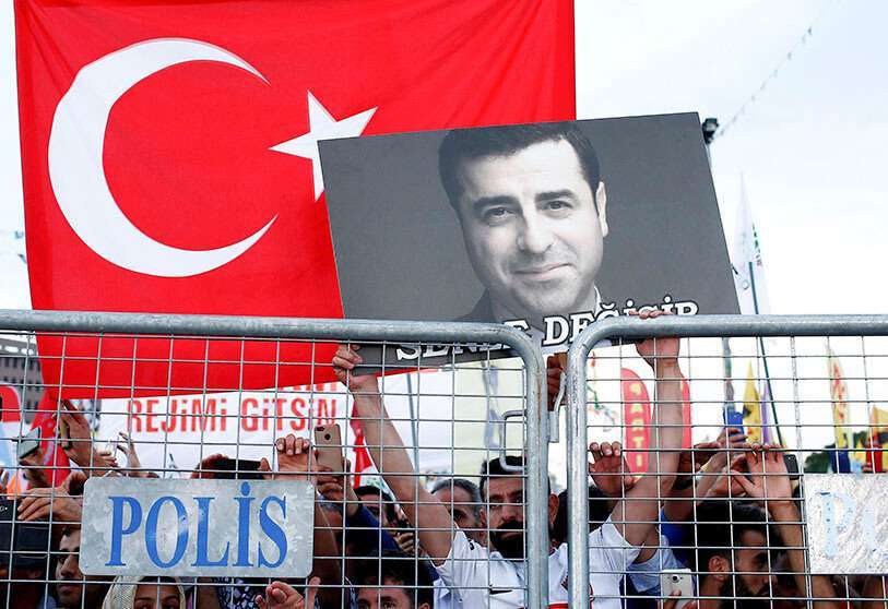 PHOTO/REUTERS - Photo d'archive, un partisan du principal parti démocratique populaire de Turquie tient un portrait de son ancien leader et candidat présidentiel emprisonné, Selahattin Demirtas, lors d'un événement de campagne à Istanbul, le 17 juin 2018