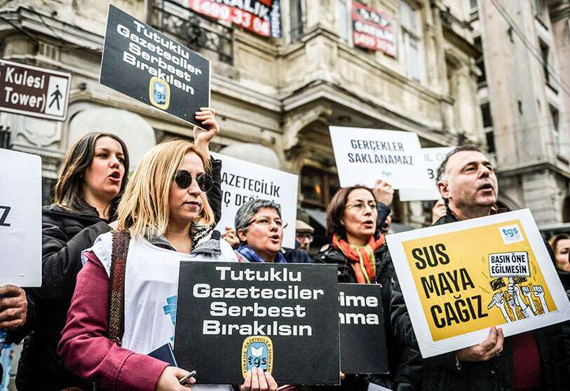 Los periodistas sostienen carteles que dicen “no nos callaremos” durante una protesta por el encarcelamiento de trabajadores de la información