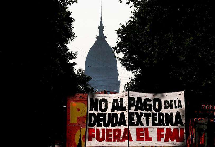 Los manifestantes sostienen una pancarta que dice "no al pago de la deuda externa, FMI fuera" mientras marchan hacia el Palacio Presidencial de la Casa Rosada durante una protesta contra la visita de un equipo técnico del FMI a Buenos Aires, Argentina el 12 de febrero de 2020