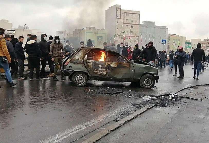 Manifestantes iraníes se reúnen alrededor de un coche en llamas durante una manifestación contra el aumento de los precios de la gasolina en la capital Teherán, el 16 de noviembre de 2019