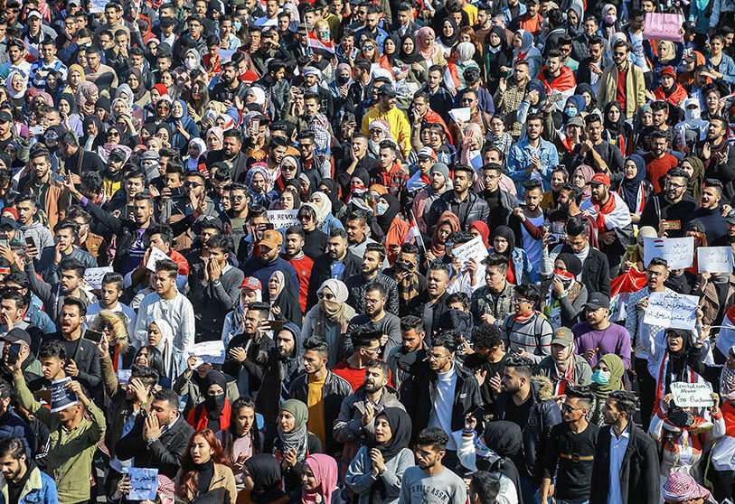 Estudiantes iraquíes sostienen carteles y gritan consignas durante una manifestación en la Plaza Tahrir contra Mohammed Tawfiq Allaui
