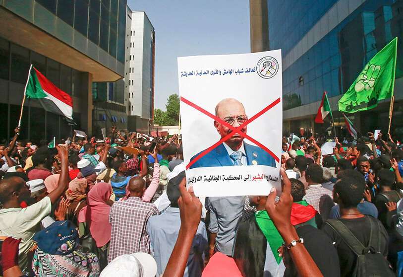 Un manifestante sudanés sostiene una pancarta con la cara de Omar al-Bashir, en la que se puede leer en árabe “Butcher Bashir to the International Criminal Court” (“Carnicero Bashir ante la Corte Penal Internacional”), durante una protesta el 19 de septiembre de 2019