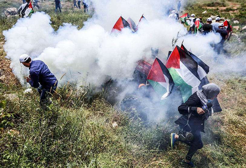 Manifestantes palestinos frente a fuerzas de seguridad israelíes