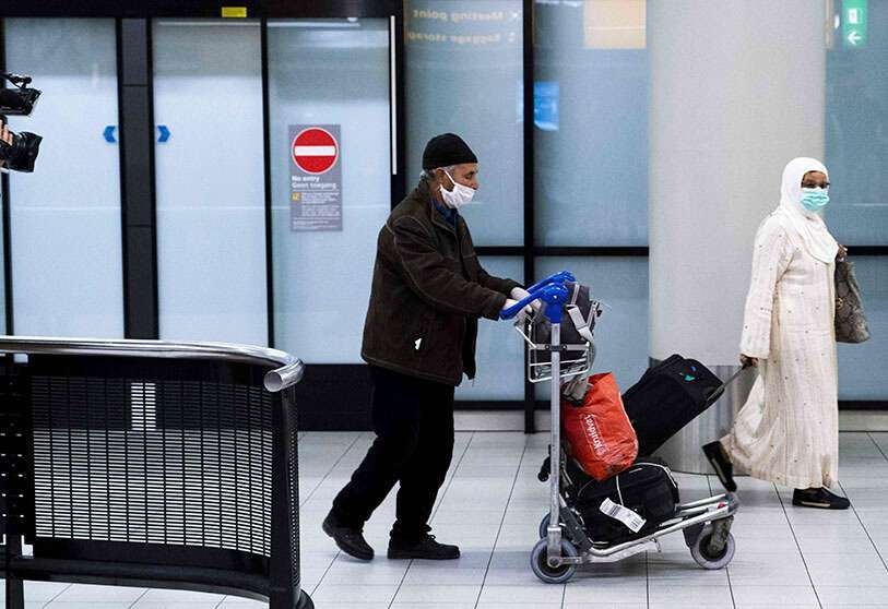 Pasajeros del primer vuelo de repatriación partido desde Casablanca caminan por el interior del aeropuerto de Schipol en Ámsterdam, el 27 de abril de 2020