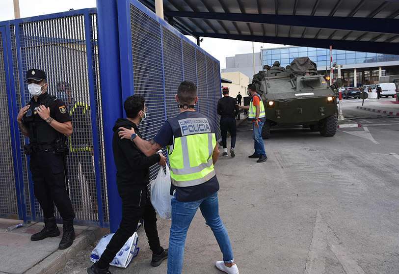Policías españoles controlan a los migrantes que cruzan la frontera con Marruecos en el enclave español de Ceuta el 20 de mayo de 2021