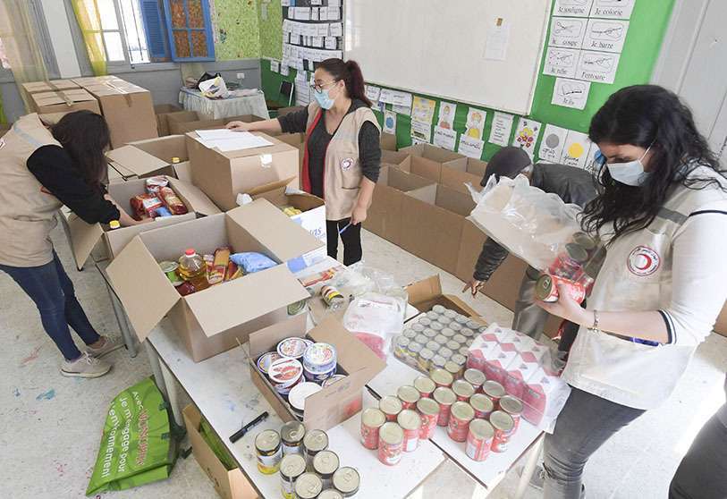 Miembros de la Media Luna Roja Tunecina preparan paquetes de alimentos para los ancianos y las familias de bajos ingresos en la ciudad costera de Ezzahra, cerca de Túnez
