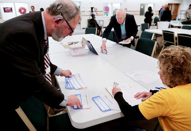 Trabajadores de la circunscripción de Iowa cuentan a mano los votos tras un caucus en la Iglesia Cristiana West Des Moines