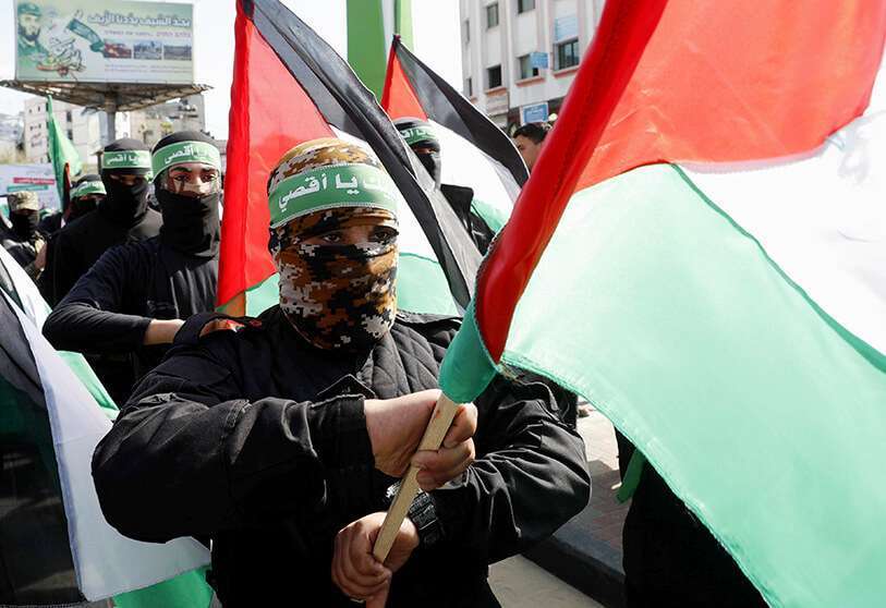 Militantes enmascarados de Hamás ondean sus banderas nacionales durante una protesta contra el plan de Oriente Medio anunciado por Donald Trump