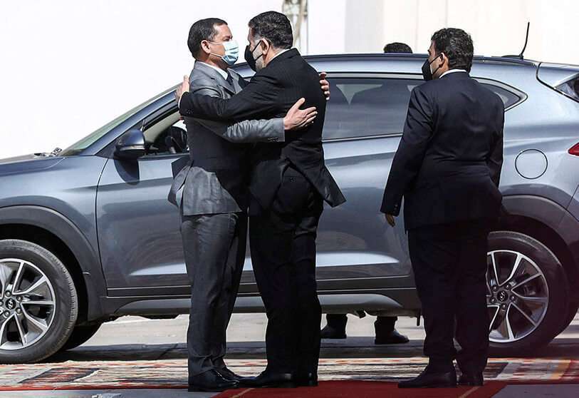 Mohamed al-Menfi (Derecha), jefe del Consejo de la Presidencia de Libia, junto al nuevo primer ministro interino Abdul Hamid Dbeiba (Izquierda) abraza al jefe saliente del GNA, Fayez al-Sarraj (Centro), antes de la salida de este último durante el traspaso formal en la sede del Consejo Presidencial en Trípoli, capital de Libia, el 16 de marzo de 2021