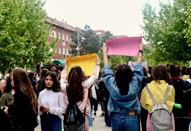 Tres chicas en la manifestación sosteniendo en alto los carteles