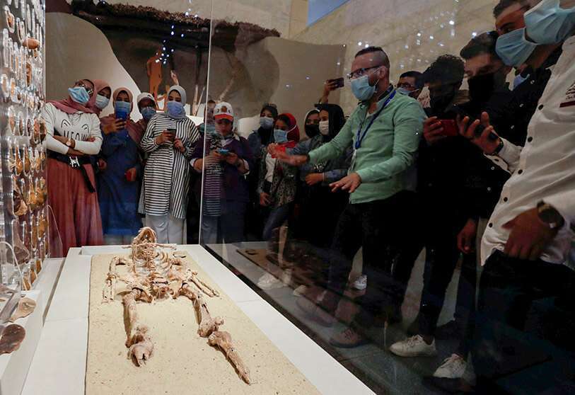 Los visitantes observan un esqueleto de 35000 años de antigüedad que se expone en el Museo Nacional de la Civilización Egipcia