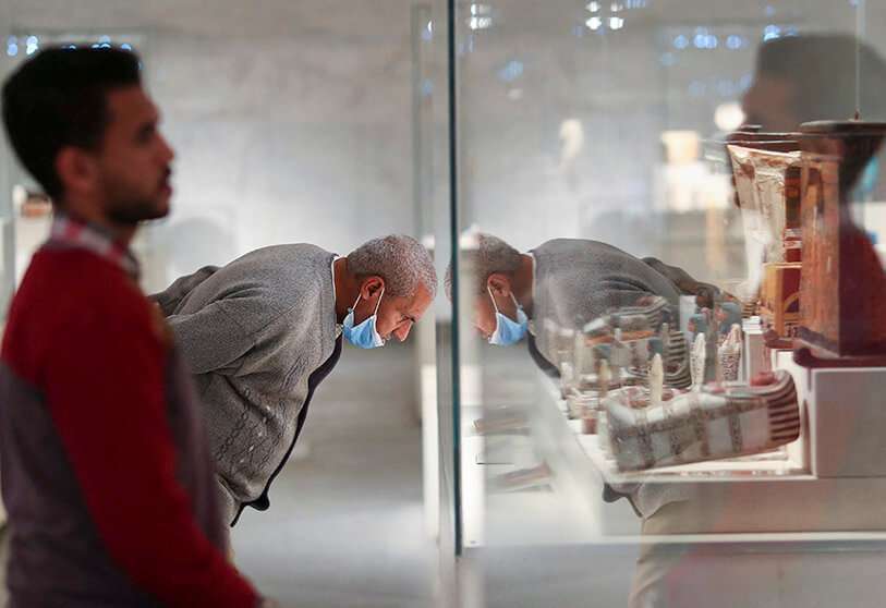 Visitantes observan los artefactos expuestos en el nuevo Museo Nacional de la Civilización Egipcia (NMEC), en el distrito de Fustat, en el Viejo Cairo, durante su reapertura oficial un día después de la ceremonia del Desfile de Oro de los Faraones, el 4 de abril de 2021