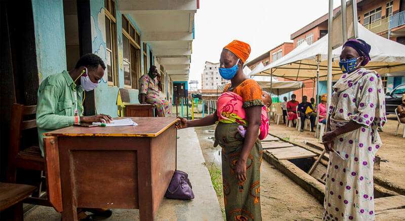 Mujeres nigerianas toman vales de alimentos como parte de un programa de apoyo a las familias que luchan contra el confinamiento de la COVID-19PMA/Damilola Onafuwa