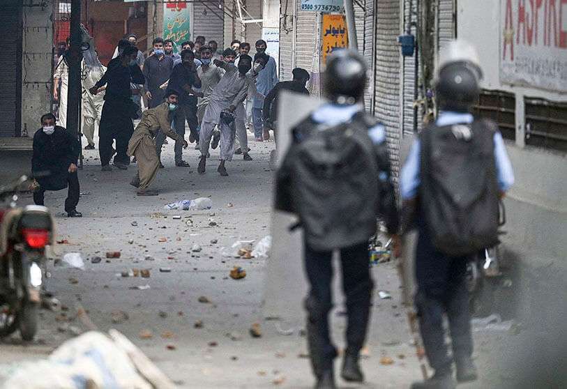 Simpatizantes del partido Tehreek-e-Labbaik Pakistan (TLP) lanzan piedras hacia los policías antidisturbios durante una protesta contra el arresto de su líder cuando pedía la expulsión del embajador francés AFP/AAMIR QURESHI