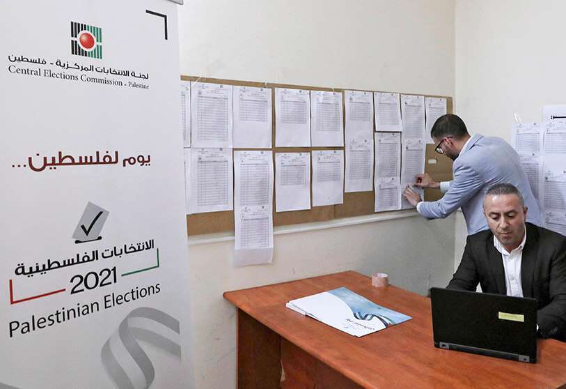 Empleados de la Comisión Electoral Central Palestina muestran las listas electorales antes de las próximas elecciones generales, en las oficinas de distrito de la comisión en la ciudad de Hebrón, en la Cisjordania ocupada por Israel, el 6 de abril de 2021 AFP/ HAZEM BADER