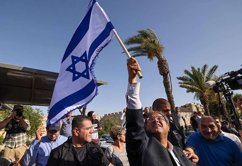 Ittamar Ben-Gvir, miembro de la Knesset (parlamento) de Israel y jefe del partido unipersonal de extrema derecha "Poder Judío" (Otzma Yehudit), agita una bandera israelí mientras intenta marchar hacia la Puerta de Damasco en el este de Jerusalén, el 10 de junio de 2021 AFP/ EMMANUEL DUNAND