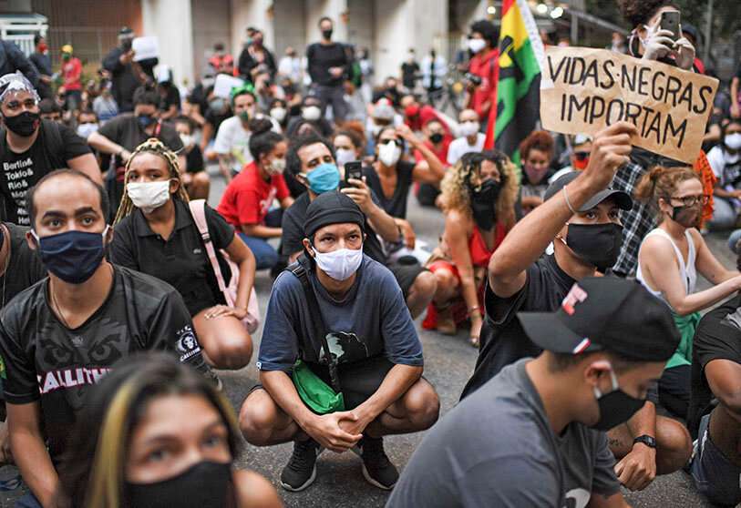 Personas con un cartel que dice las “vidas negras importan” participan en una protesta en las afueras del Palacio de Guanabara
