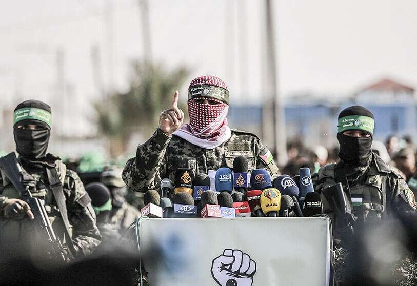 Abu Ubaida (C), portavoz de las Brigadas Izz ad-Din al-Qassam, el ala militar de la organización palestina Hamas, pronuncia un discurso durante un desfile militar contra Israel