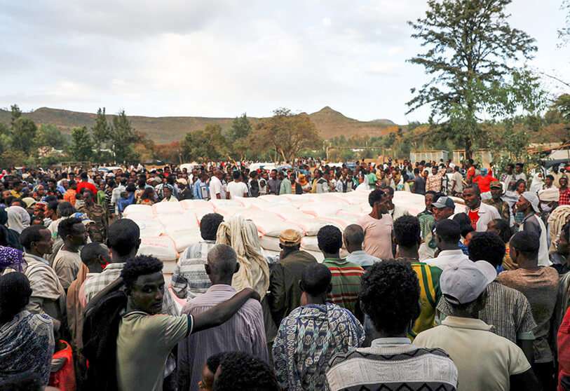La gente hace cola para recibir donaciones de alimentos, en la escuela primaria de Tsehaye, que se convirtió en un refugio temporal para las personas desplazadas por el conflicto, en la ciudad de Shire, región de Tigray, Etiopía, 15 de marzo de 2021