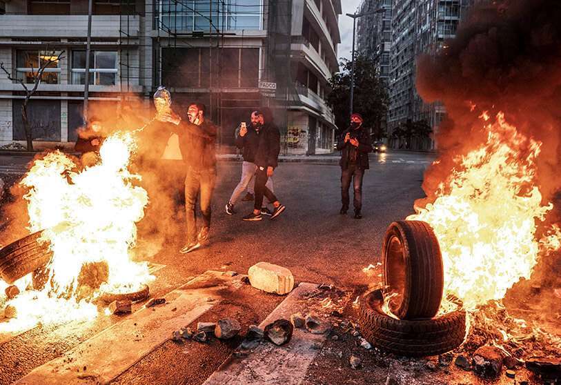 En esta foto de archivo del 3 de marzo de 2021, un joven lanza gasolina para prender fuego a los neumáticos que bloquean una carretera, durante una protesta en el centro de Beirut, Líbano