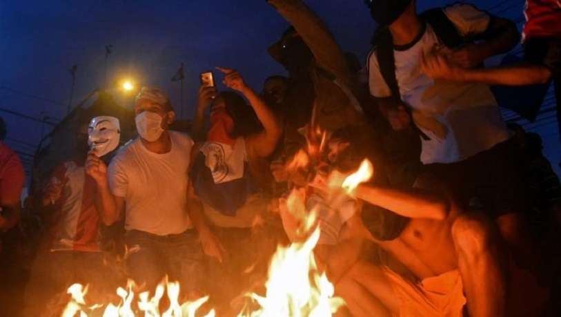 Manifestantes rodean una hoguera durante una protesta contra las carencias del sistema sanitario, exigiendo la renuncia del presidente paraguayo Mario Abdo Benítez, en Asunción, el 5 de marzo de 2021