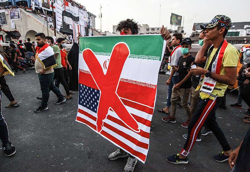 Un manifestante sostiene una pancarta contra Estados Unidos e Irán durante una protesta antigubernamental cerca de la plaza Tahrir