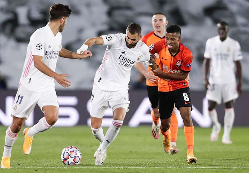 Karim Benzema del Real Madrid, centro, y Marcos Antonio del Shakhtar luchan por el balón durante la Liga de Campeones, partido de fútbol del grupo B entre el Real Madrid y el Shakhtar Donetsk en el estadio Alfredo di Stéfano de Madrid, el 21 de octubre de 2020