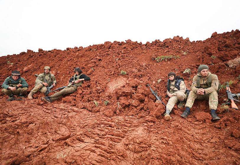 Rebeldes sirios apoyados por Turquía se reúnen en un lugar cerca de la ciudad de Taftanaz, en la provincia nororiental de Idlib, el 28 de febrero de 2020