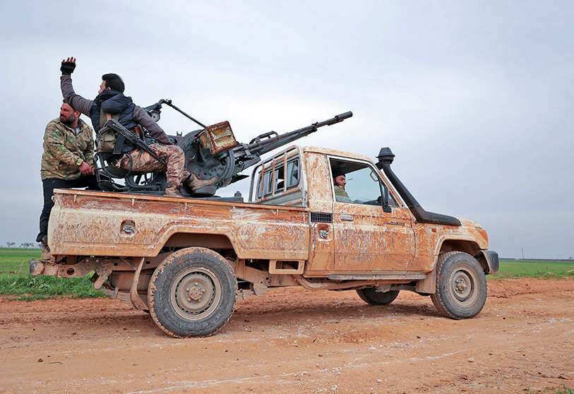 PHOTO/AFP-Syrian rebels supported by Turkey drive on a road near the town of Taftanaz in the north-eastern province of Idlib