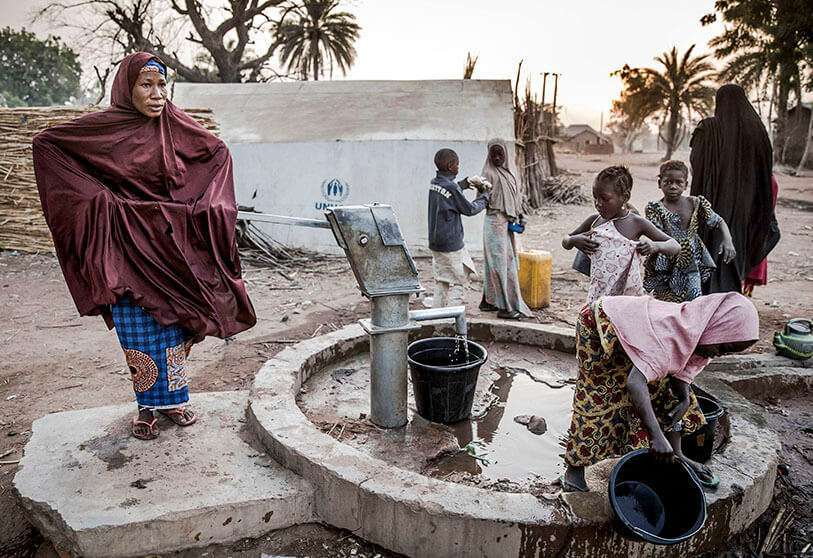 La mujer bombea agua desde un pozo en el campamento de refugiados de Malkohi en Jimeta, estado de Adamawa, Nigeria