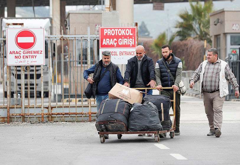 Los sirios cruzan a Turquía por la puerta fronteriza de Cilvegozu, situada frente al paso comercial sirio Bab al-Hawa, en Reyhanli, provincia de Hatay (Turquía), el 28 de febrero de 2020