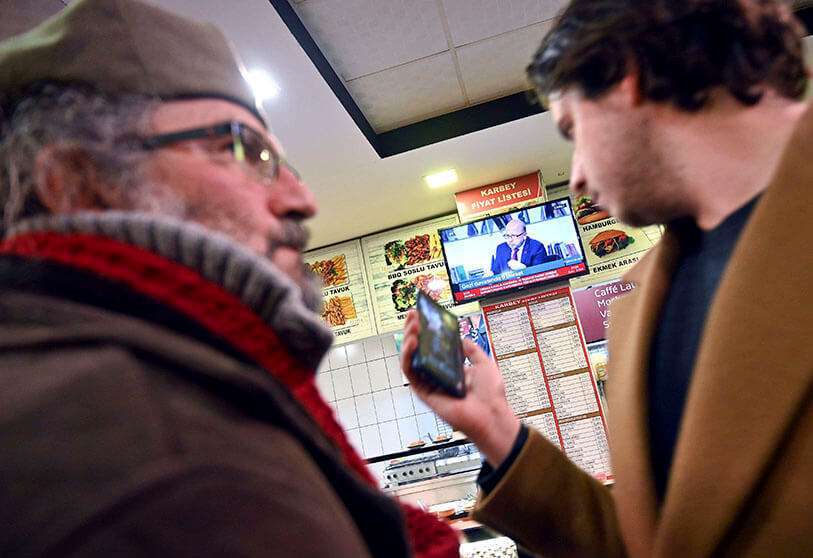 Los partidarios de Osman Kavala ven las noticias de televisión después de que los fiscales de Estambul emitieran una nueva orden de detención contra Kavala