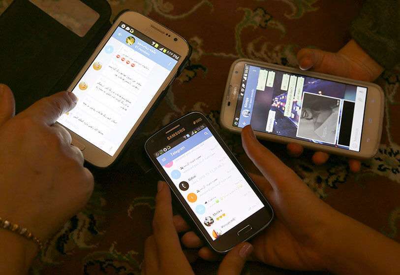 Iraníes muestran sus teléfonos inteligentes usando la aplicación de mensajería Telegram