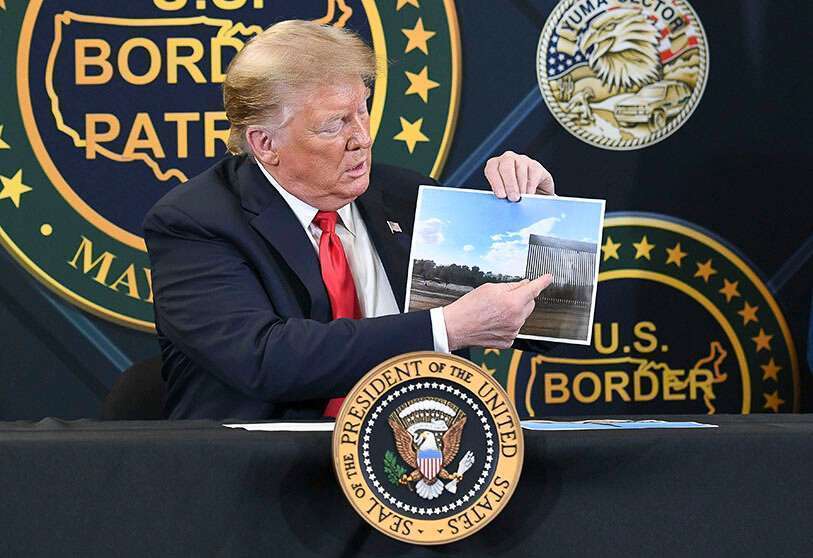 El presidente de los Estados Unidos, Donald Trump, muestra una foto del muro fronterizo entre los Estados Unidos y México mientras habla durante una mesa redonda sobre seguridad fronteriza en la Estación de Yuma de la Patrulla Fronteriza de los Estados Unidos en Yuma, Arizona, el 23 de junio de 2020