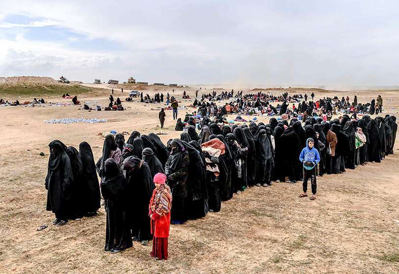 Las familias de los terroristas de Daesh esperan en un área de detección de las Fuerzas Democráticas Sirias (SDF) liderada por Estados Unidos, en la provincia oriental siria de Deir Ezzor, el 5 de marzo de 2019