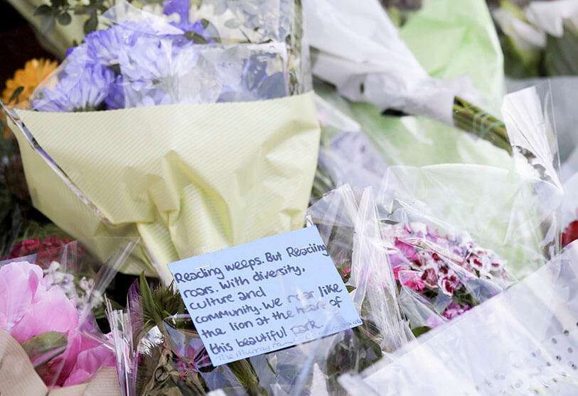 Un mensaje se muestra en las flores cerca de la escena de un fatal ataque de apuñalamiento múltiple en los Jardines de Forbury, en el centro de Reading, Inglaterra, el lunes 22 de junio de 2020