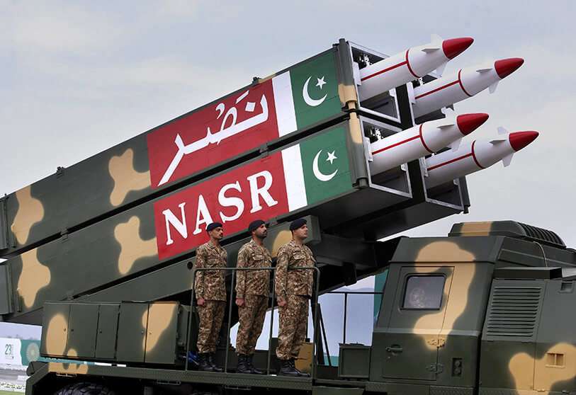 AP/ANJUM NAVEED-Un misil balístico de fabricación paquistaní NASR se carga en un remolque rueda hacia abajo durante un desfile militar para conmemorar el Día Nacional de Pakistán, en Islamabad
