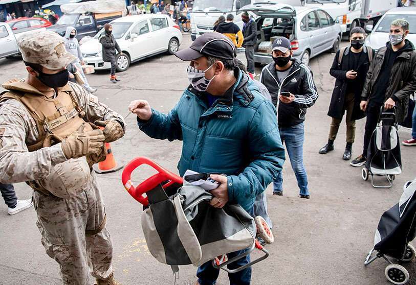 Un soldado vigila la entrada a un mercado popular de Santiago, el 22 de junio de 2020 en medio de la pandemia del nuevo coronavirus COVID-19