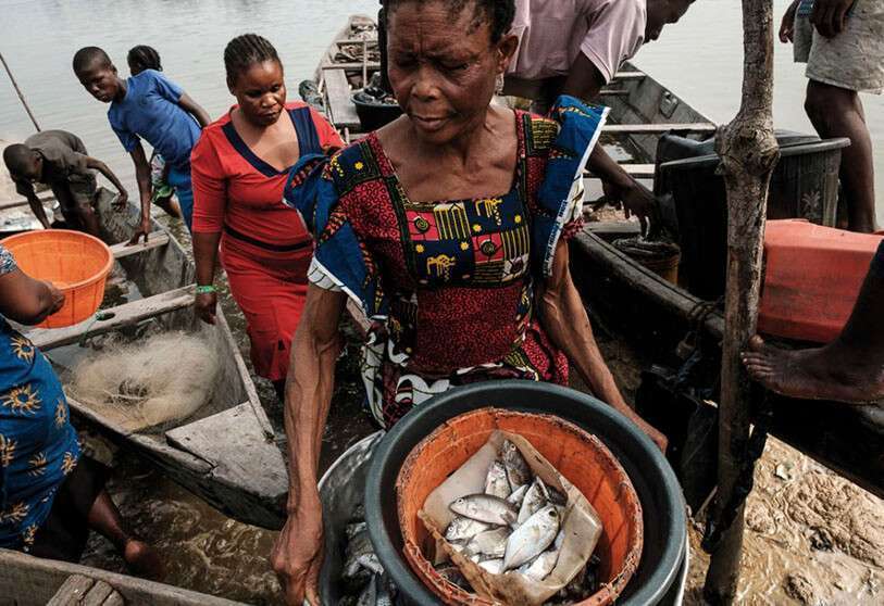 Una mujer con una cesta de pescado en el río Bodo (Nigeria)