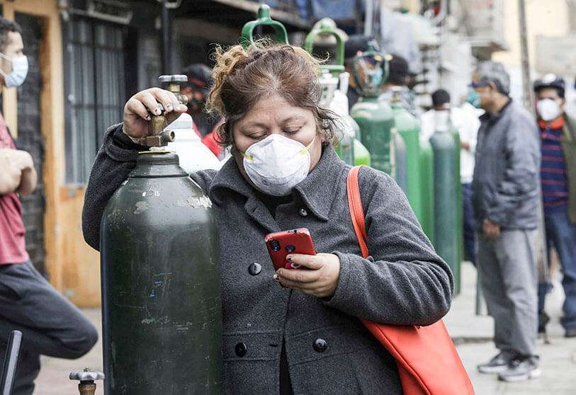 Una mujer con una máscara para prevenir la propagación del nuevo coronavirus hace cola para rellenar su cilindro de oxígeno vacío en el Callao, Perú, el miércoles 3 de 2020