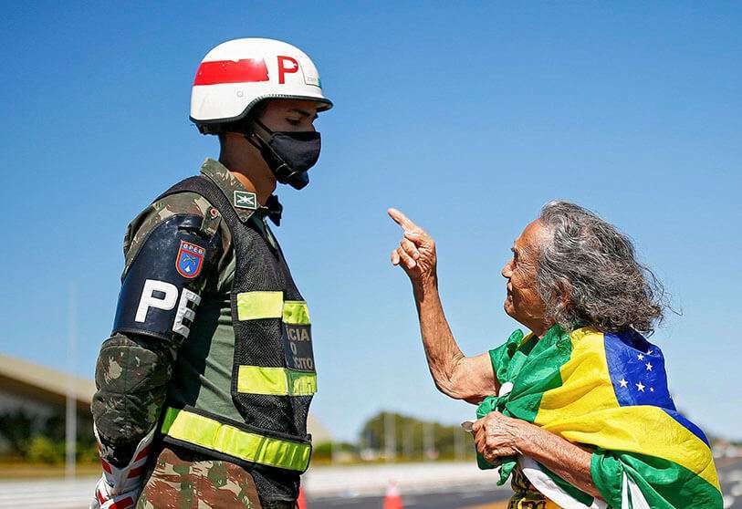 Una partidaria del presidente brasileño Jair Bolsonaro habla con un soldado mientras participa en una protesta frente al cuartel general del ejército