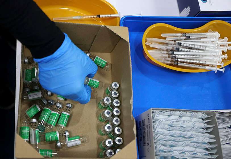 Un trabajador sanitario desecha viales usados de la vacuna Oxford contra el coronavirus en un centro de vacunación instalado en el Centro Financiero Internacional de Dubái, en el emirato del Golfo, el 3 de febrero de 2021