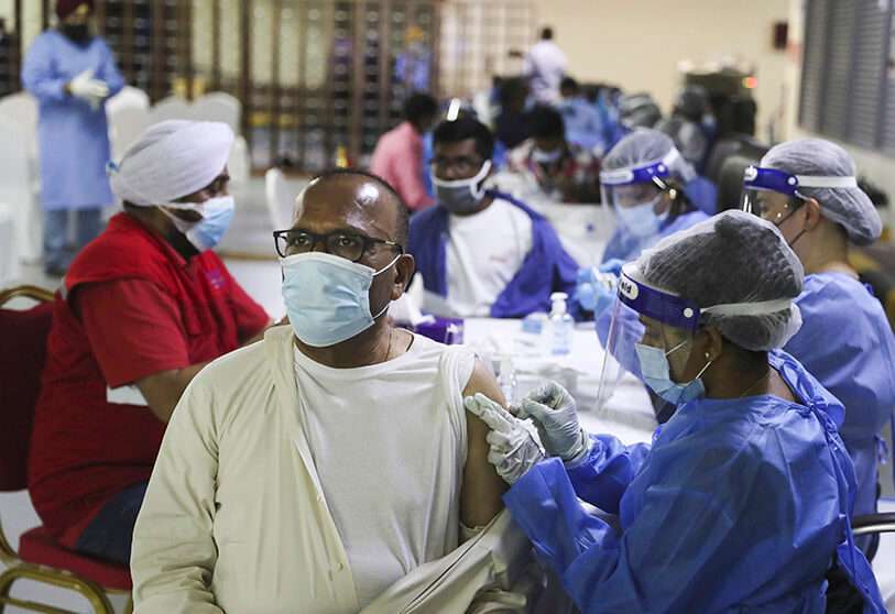 Un hombre recibe una vacuna COVID-19 de Sinopharm de manos de un personal médico en el templo sij Guru Nanak Darbar, en Dubái, Emiratos Árabes Unidos, el lunes 8 de febrero de 2021