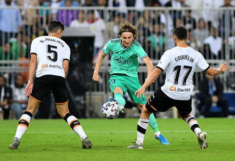 Luka Modric del Real Madrid en acción con los valencianistas Francis Coquelin y Gabriel Paulista