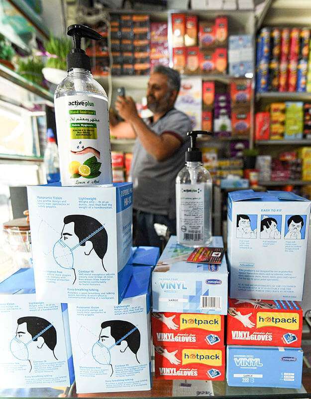 Máscaras faciales N95 y desinfectante de manos en una tienda de un mercado en el centro del emirato de Sharjah, mientras la gente compra desinfectantes para ser usados como medidas contra el coronavirus
