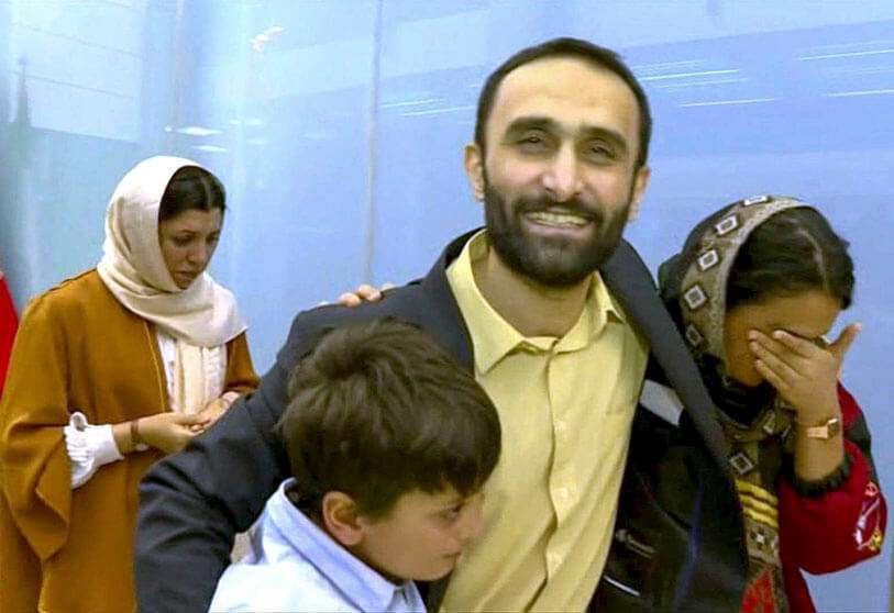 Una imagen extraída de las imágenes obtenidas de la agencia de noticias estatal Iran Press el 21 de marzo de 2020, muestra a Jallal Rohollahnejad , un iraní liberado de Francia en un intercambio de prisioneros, abrazando a sus familiares a su llegada a Teherán